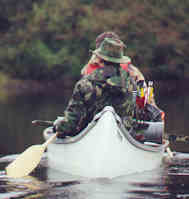 Bowhunters travelling by canoe, Northern Canadian wilderness